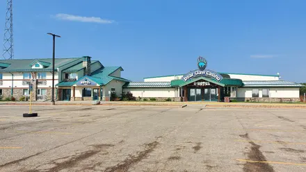 Bear Claw Casino and its hotel wing with green roofs, seen across the parking lot